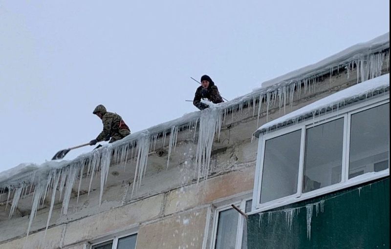 Сотрудники управляющих компаний очищают крыши многоэтажек от сосулек и наледи